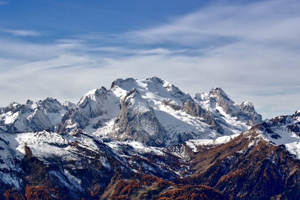 snowy mountain range with blue skies behind it